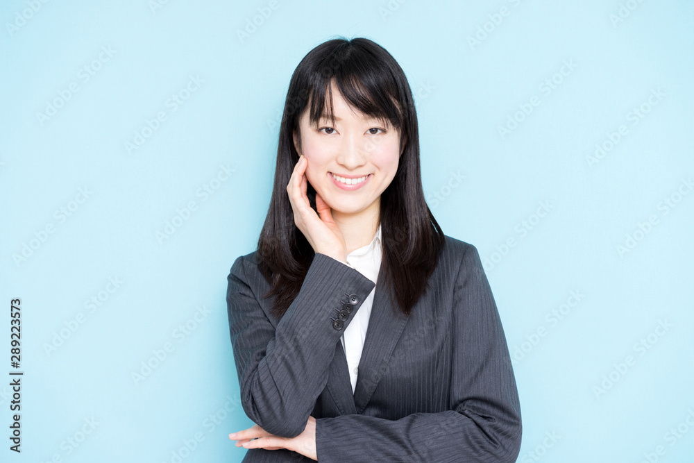Young business woman thinking against light blue background Young business woman thinking against light blue background