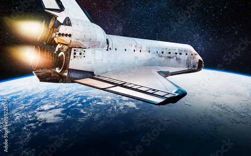 Fototapeta Naklejka Na Ścianę i Meble -  Space shuttle in dark outer space near Earth. Rocket on orbit of the planet. Elements of this image furnished by NASA