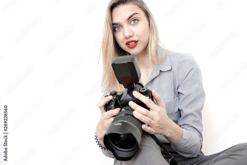 Beautiful young blonde with a big camera looks into the camera, toning Beautiful young blonde with a big camera looks into the camera, toning
