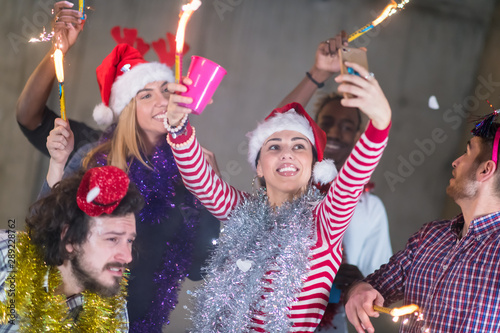 multiethnic group of casual business people taking selfie during new year party