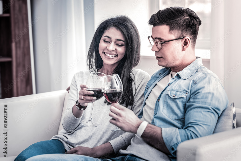 Pleasant couple spending time together with glasses of wine