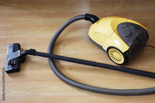 Old vacuum cleaner on parquet floor