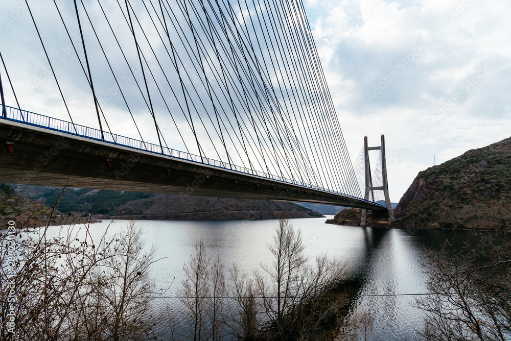 Obraz premium Modern suspension bridge across reservoir Los Barrios de Luna