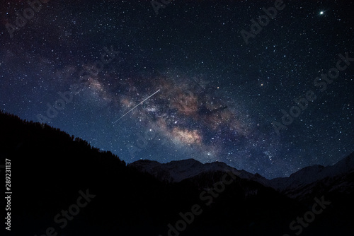 milky way galaxy with shooting star and snow mountain 