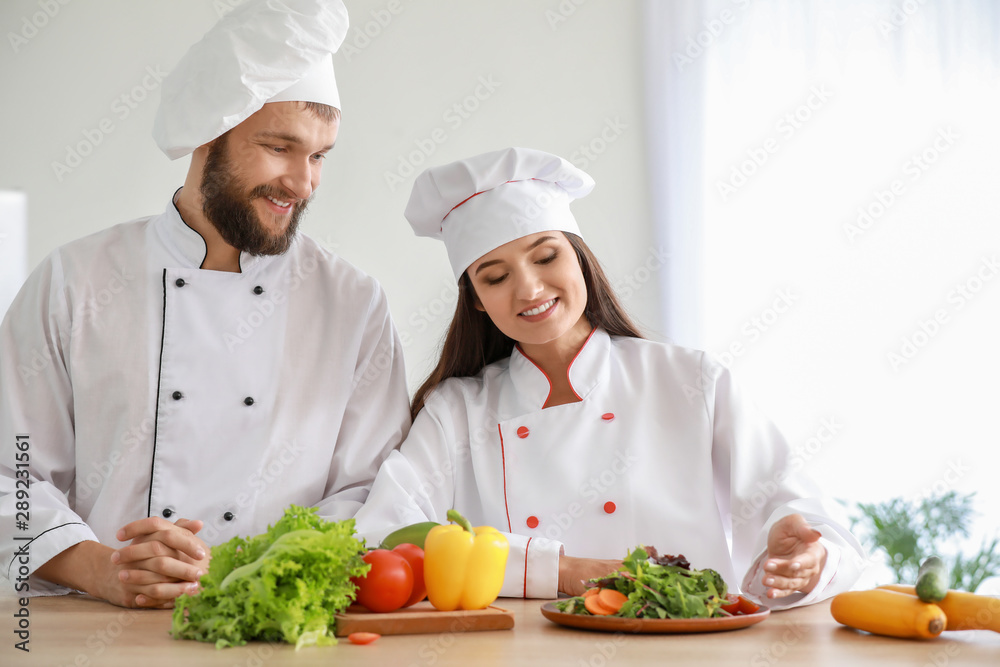 Professional chefs preparing vegetable salad in kitchen Professional chefs preparing vegetable salad in kitchen