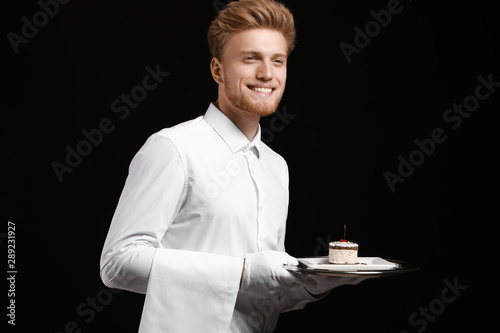 Handsome waiter with desser...