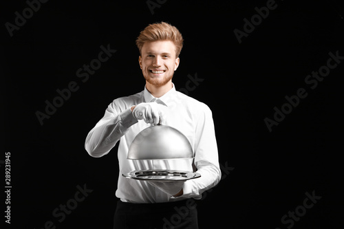 Handsome waiter with tray a...