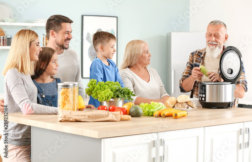 Happy family using modern multi cooker in kitchen