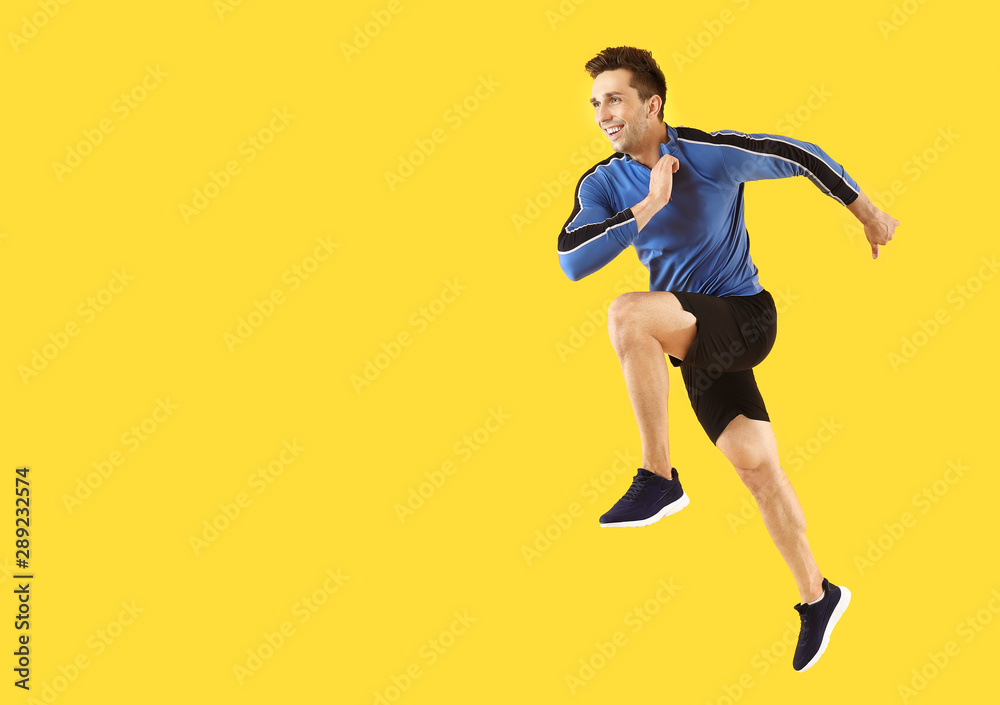 Running sporty man on color background