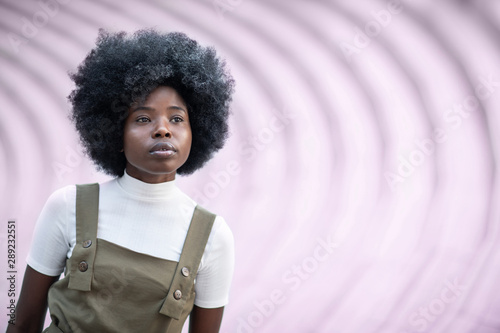 Inspired African American woman looking afar, standing on concrete stairs in the city photo