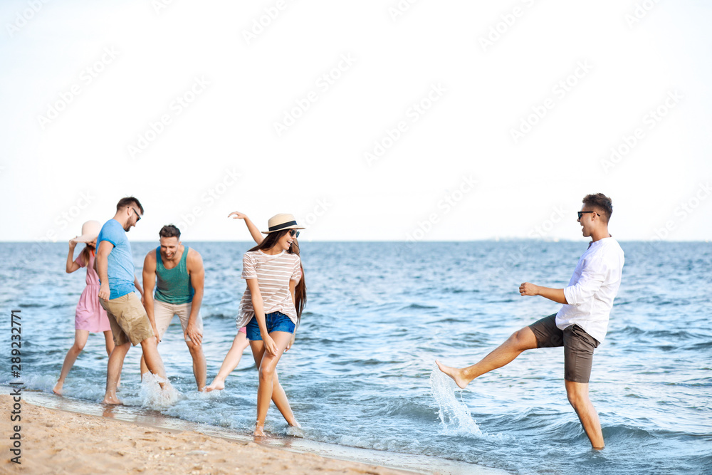 Happy friends on sea beach at resort