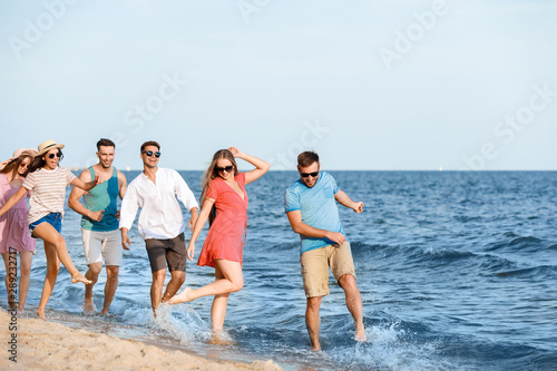 Happy friends on sea beach at resort