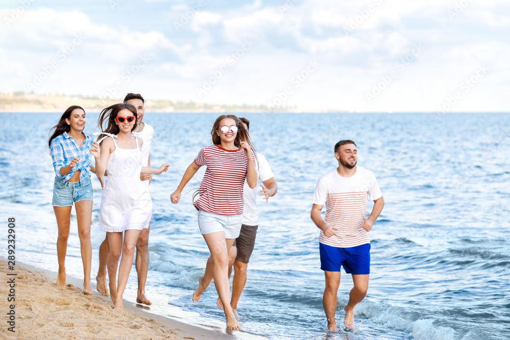 Happy friends running on sea beach at resort Happy friends running on sea beach at resort
