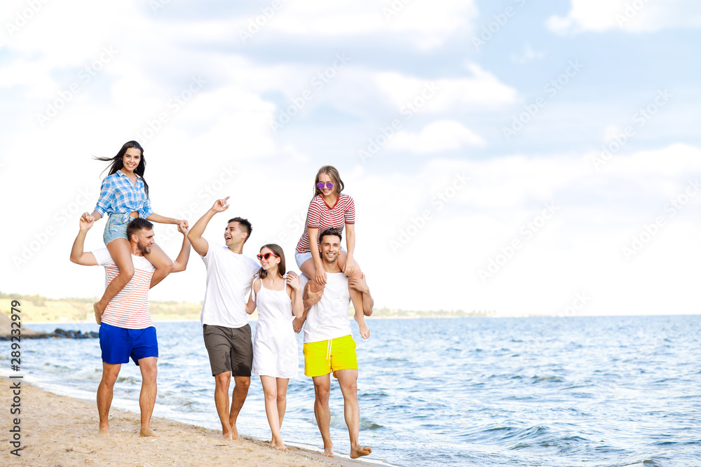 Happy friends on sea beach at resort