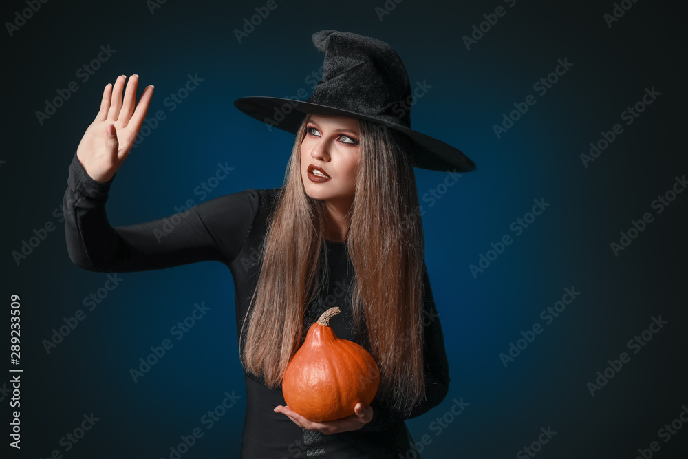 Beautiful woman dressed as witch for Halloween on dark background Beautiful woman dressed as witch for Halloween on dark background