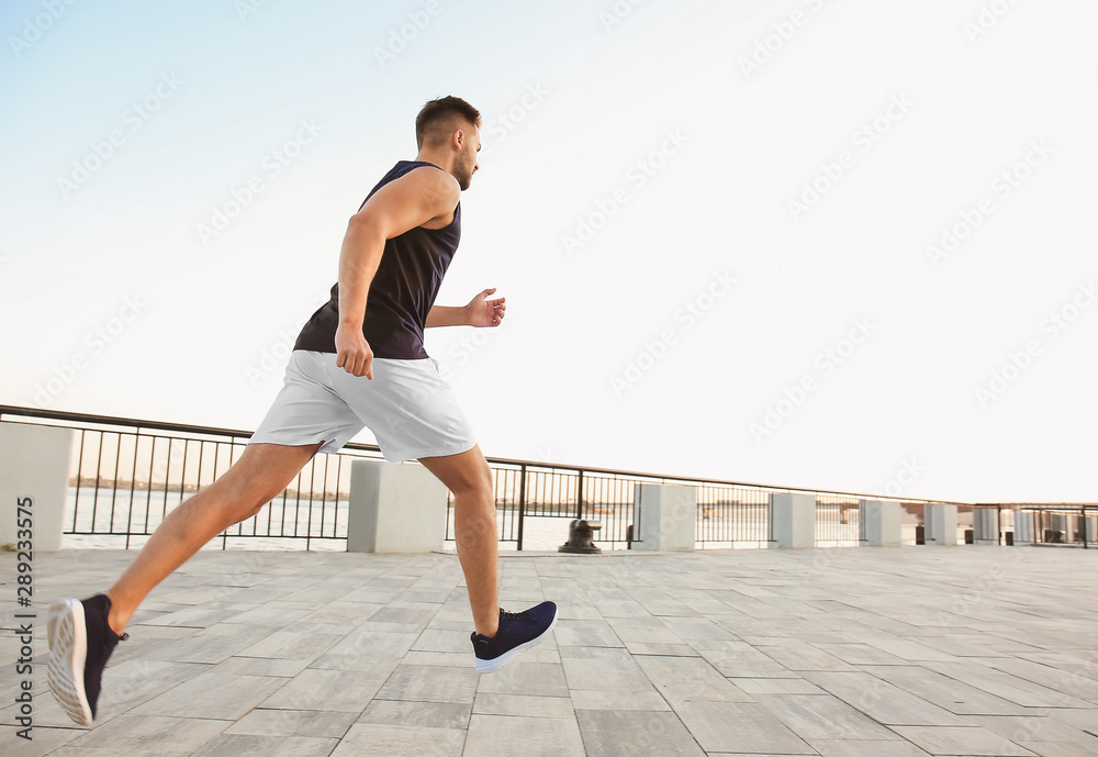 Handsome sporty man running outdoors