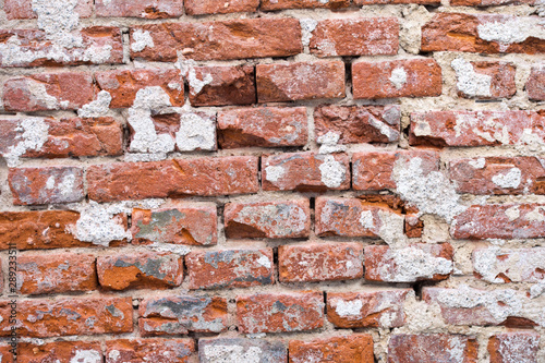 Old brick wall background in Prague. Background of old vintage dirty brick wall with peeling plaster, texture.