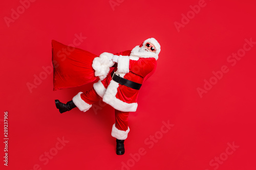 Full length body size view of his he tired generous funky fat overweight plump gray-haired bearded man carrying purchases christmastime isolated over bright vivid shine red background © deagreez