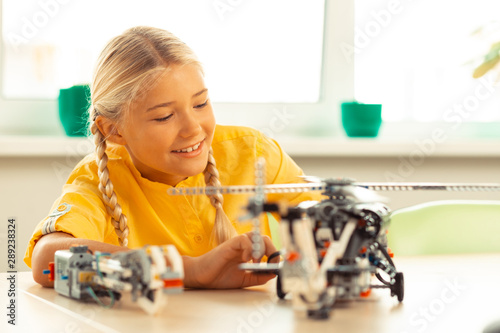 Wallpaper Mural Interested schoolgirl looking closely at helicopter model. Torontodigital.ca
