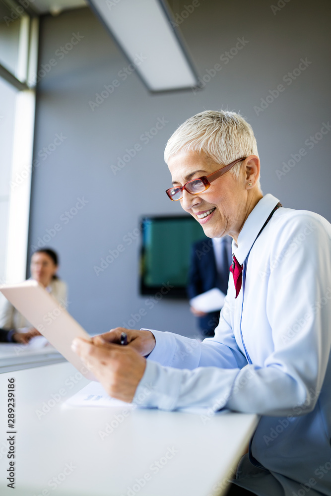 Smiling mature business woman working at modern office Smiling mature business woman working at modern office