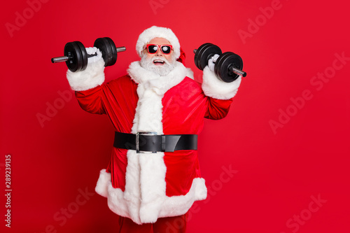 Portrait of his he cheerful cheery confident funky fat overweight plump gray-haired bearded man lifting weight making exercise aerobics isolated over bright vivid shine red background