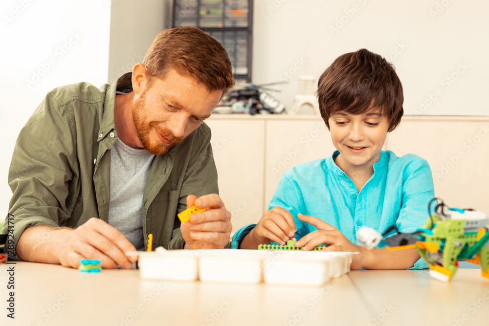 Science teacher building a house with a pupil. Science teacher building a house with a pupil.