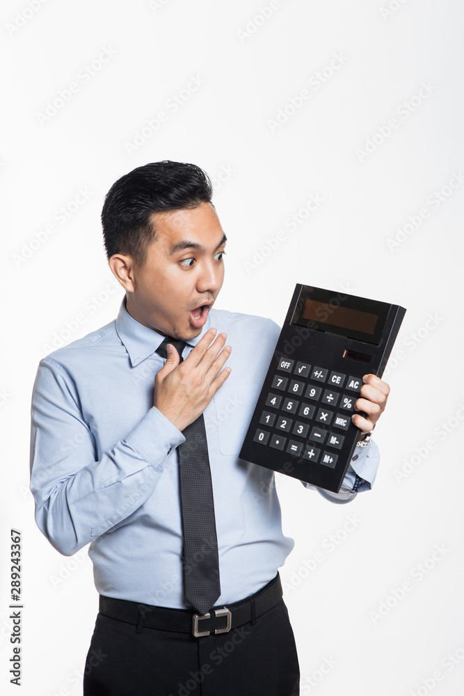 Man shocked when looking at big calculator Man shocked when looking at big calculator