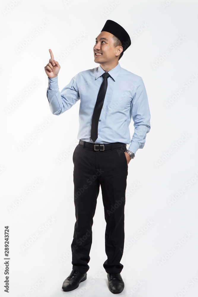 Asian business man in suit and songkok pointing his hands Asian business man in suit and songkok pointing his hands