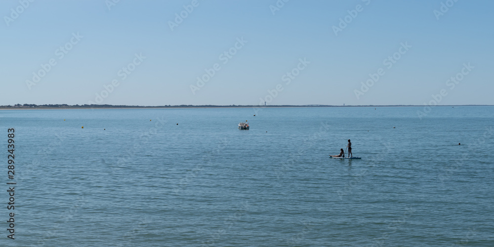 panorama young girls on stand up paddle board sap in water sea beach summer season boat and ship vacation concept