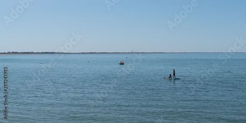 panorama young girls on stand up paddle board sap in water sea beach summer season boat and ship vacation concept