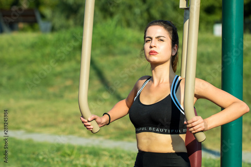 Young and pretty woman training in the outdoor fitness park