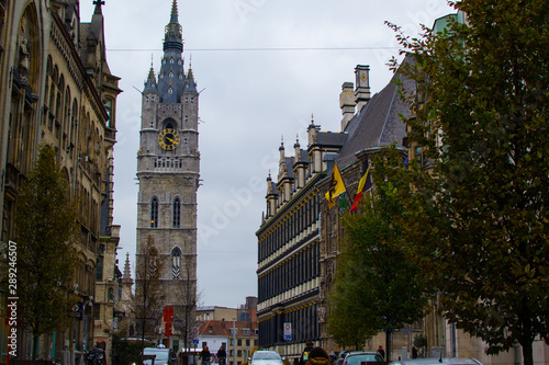 Botermarkt, one of the main streets in the old town of Ghent, Belgium, Europe, with the Town Hall on the right side and the Belfry (Bell tower or Het Belfort) at the background