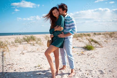 wonderful young couple hug and enjoy life together with natural outdoor laisure activity lifestyle at the beach during the summer and the sunset in backlight. photo