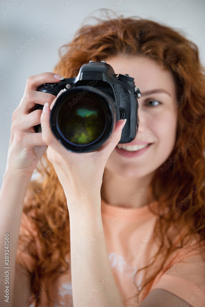 Happy woman using photo camera in modern light interior Happy woman using photo camera in modern light interior