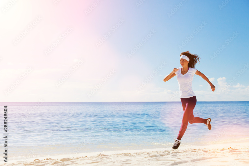 Young woman running on the beach. Summer concept. Healthy lifestyle. White sand, blue sky and crystal sea of tropical beach. Vacation at Paradise. Ocean beach relax, travel Young woman running on the beach. Summer concept. Healthy lifestyle. White sand, blue sky and crystal sea of tropical beach. Vacation at Paradise. Ocean beach relax, travel