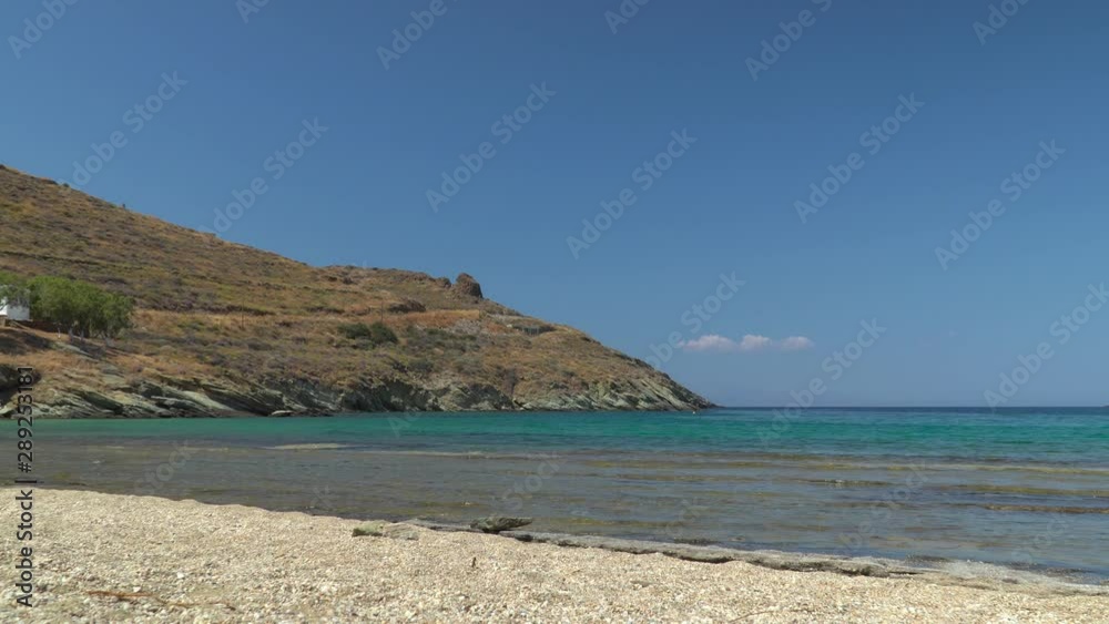 Static view over rocky beach, ocean and hills with in the background Static view over rocky beach, ocean and hills with in the background
