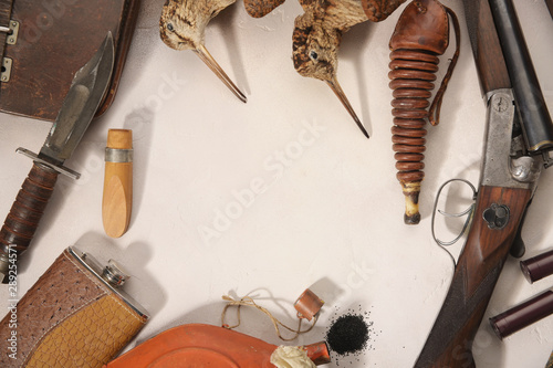 Hunting concept with woodcock, shotgun, knife and ammunition for hunting arranged on light background.