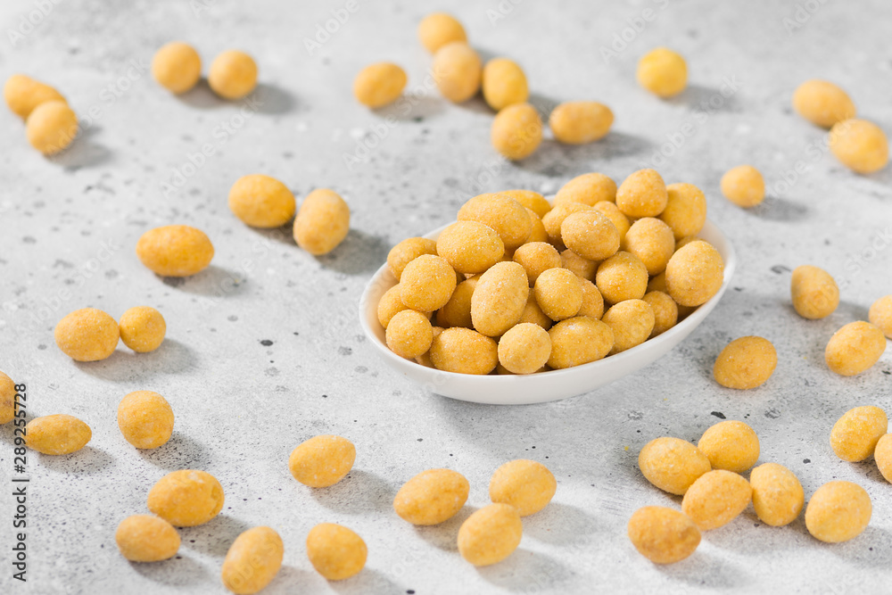 Peanuts in cheese sauce in a white bowl on a light gray table Peanuts in cheese sauce in a white bowl on a light gray table