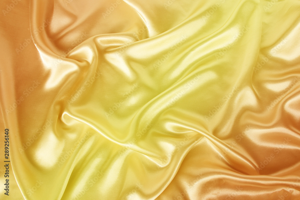 Fototapeta premium miękkie fałdy na delikatnym żółtym błyszczącym jedwabiu, luksusowa koncepcja, tło dla projektanta, poziome, zbliżenie, kopia przestrzeń