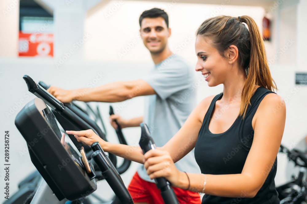 Adult couple is working out on Step climber machine in fitness gym for healthy lifestyle concept.