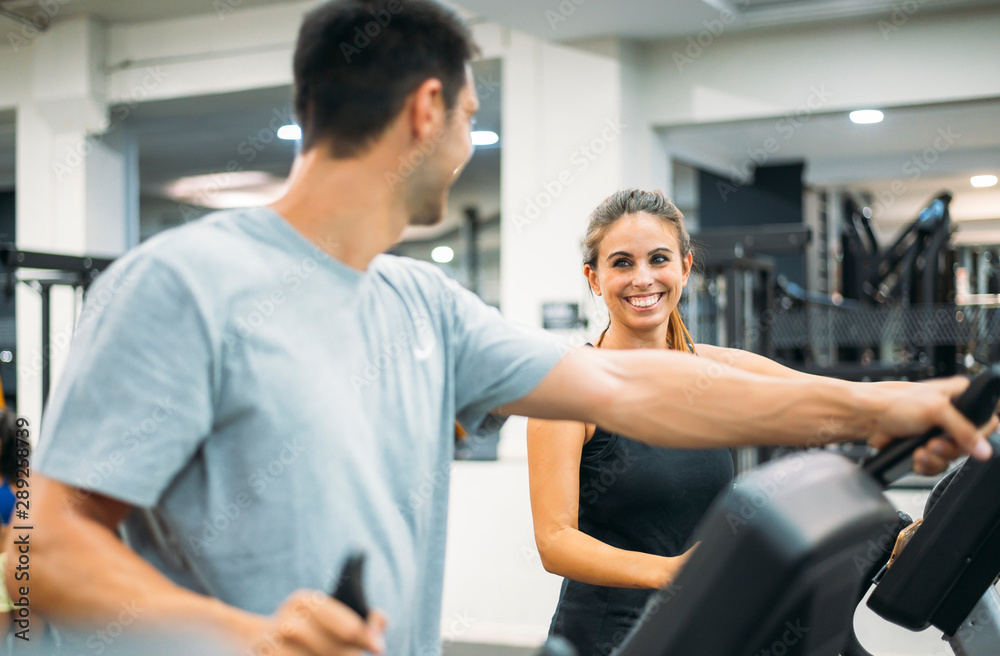 Obraz premium Adult couple is working out on Step climber machine in fitness gym for healthy lifestyle concept.