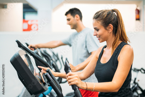 Adult couple is working out on Step climber machine in fitness gym for healthy lifestyle concept.