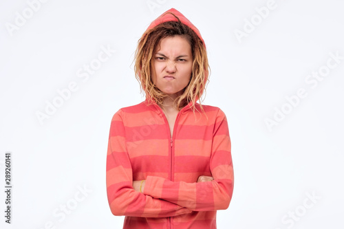 annoyed asian woman with crossed arms frowning face in disgust isolated on white wall. Studio shot. Negative facial human emotion. I am pissed off listening to you.