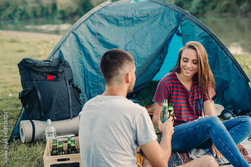 friends drinking beer on camping outdoor by the river