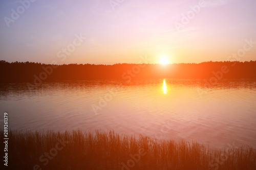 Sunset over the lake. The sky is in red rays.