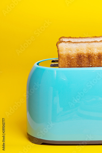 cyan color toaster on a yellow background