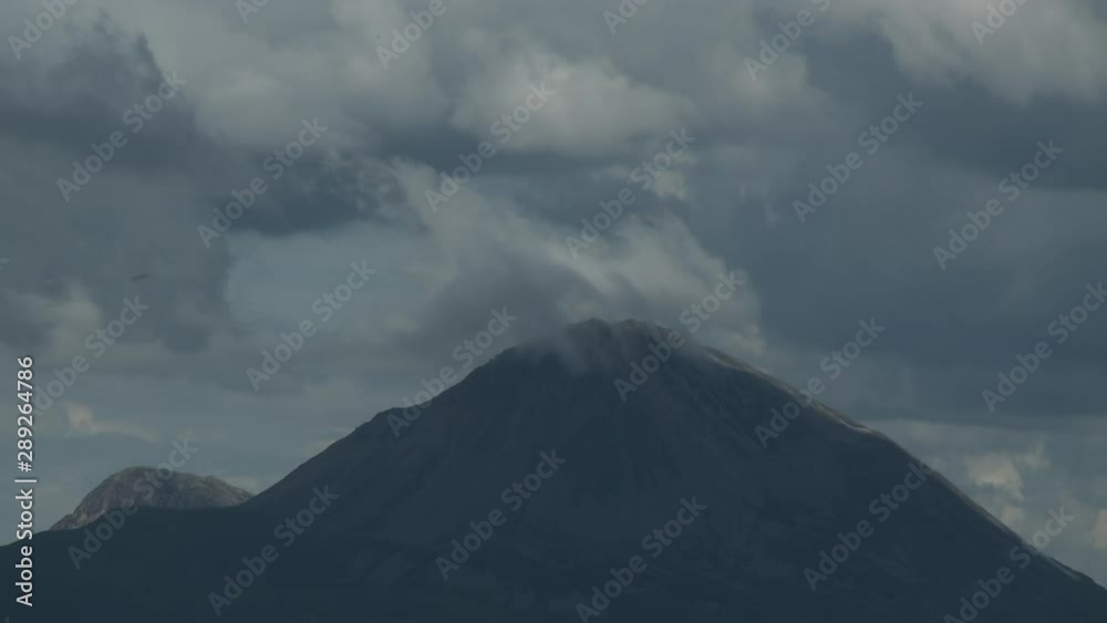 Steady, medium wide shot of a mountain with a cloud on top. Steady, medium wide shot of a mountain with a cloud on top.