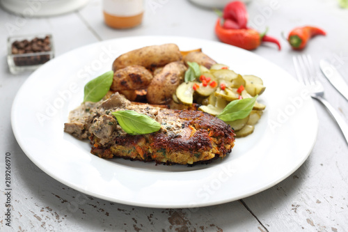 Lentil cutlet with mushrooms served with cucumber salad and potatoes