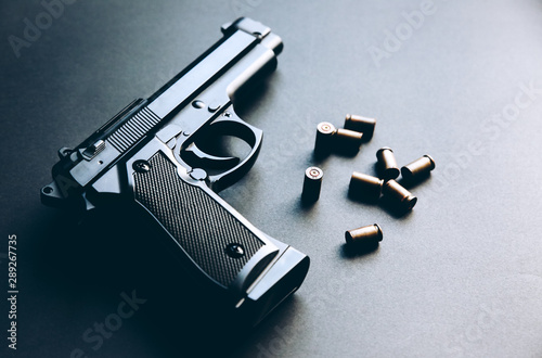 Gun with bullets lying on the table. Legalising of weapons. Criminal problems. photo