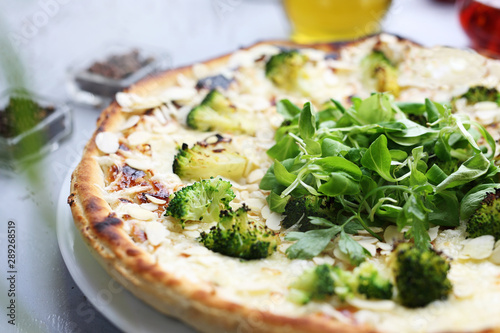 Pizza with broccoli, garlic sauce, mozzarella cheese and almonds